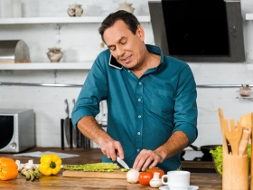 man chopping vegetables in a kitchen